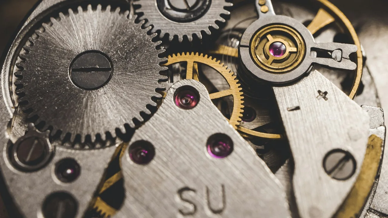 Macro photograph of mechanical gears and antique brass watch mechanism with chiaroscuro studio lighting