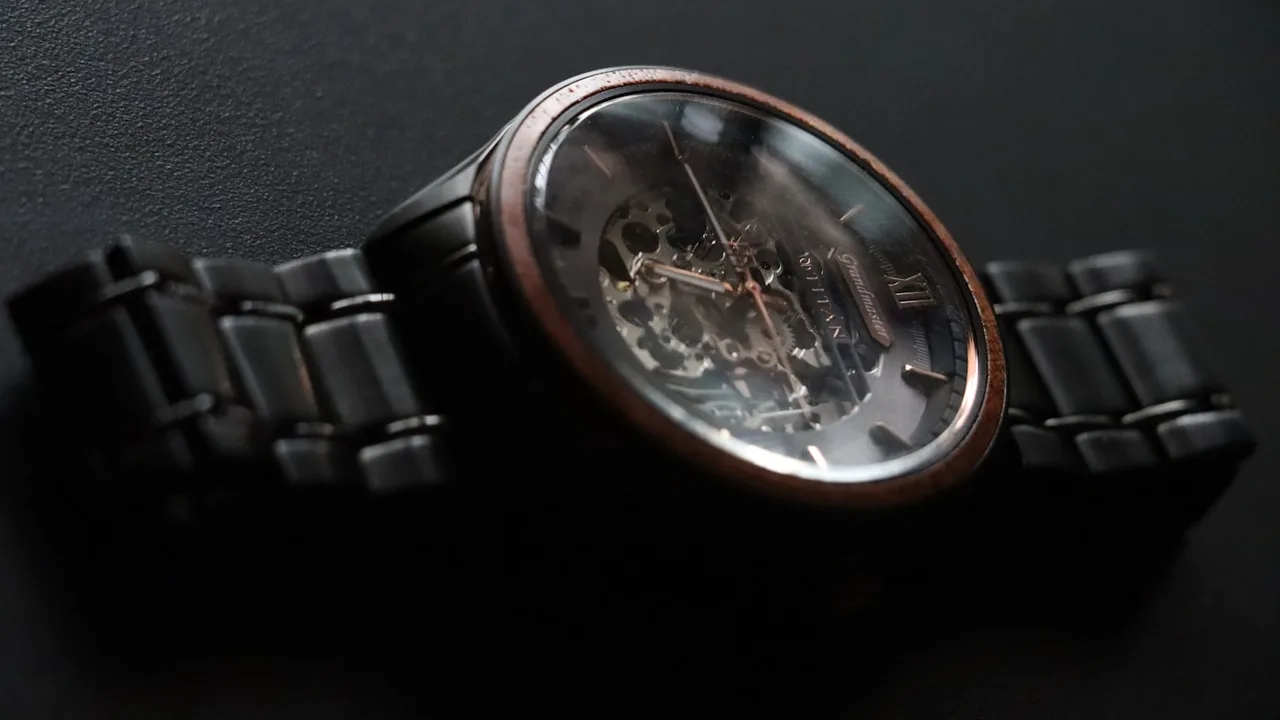Industrial design studio photography of a luxury mechanical watch against dark textured basalt slate